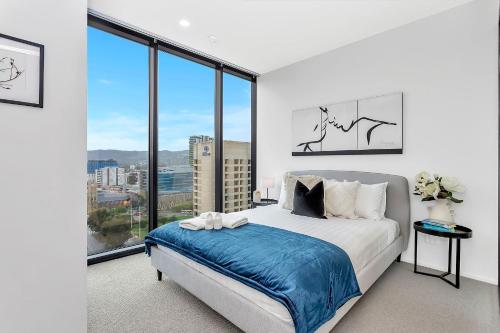 a bedroom with a bed and a large window at Level 18 Heart of Adelaide with Gym, City Views in Adelaide