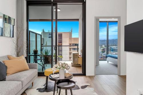 a living room with a couch and a table at Level 18 Heart of Adelaide with Gym, City Views in Adelaide