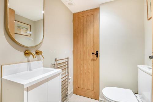 a bathroom with a sink and a mirror and a toilet at 3 Bed in Westmancote oc-t30722 in Kemerton