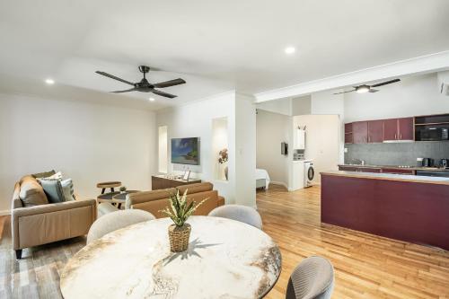 a living room with a table and chairs and a kitchen at Azabu Retreat in Byron Bay
