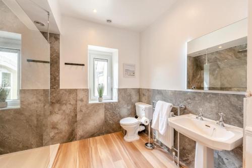 a bathroom with a sink and a toilet and a mirror at 3 Bed in Woolacombe oc-d32422 in Woolacombe