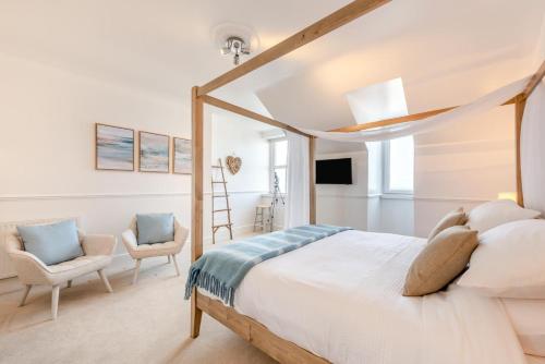 a bedroom with a bed and two chairs at 3 Bed in Woolacombe oc-d32422 in Woolacombe
