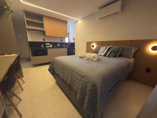 a bedroom with a bed with two towels on it at Lindo Studio com rooftop e piscina in Cabedelo