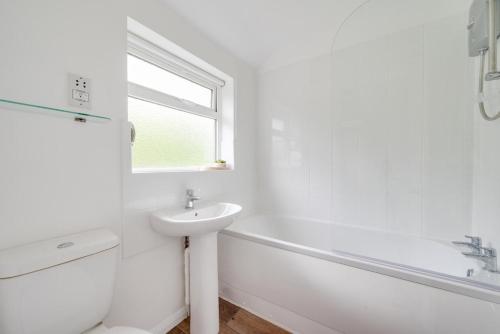 a white bathroom with a sink and a bath tub at 2 Bed in Kelling oc-1716 in Kelling