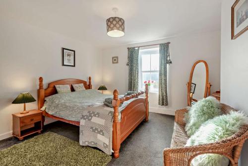 a bedroom with a bed and a chair and a window at 3 Bed in Bowness-on-Solway oc-p28797 in Bowness-on-Solway