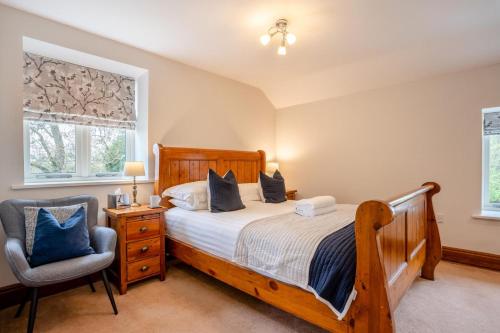 a bedroom with a bed and a chair and windows at 2 Bed in Crakehall oc-m30355 in Crakehall