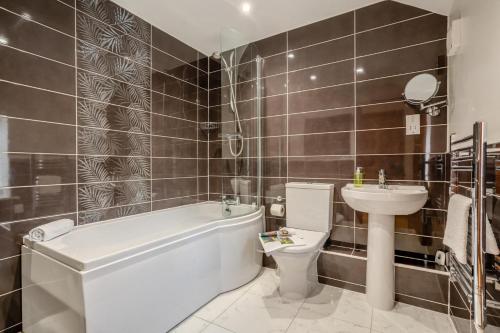 a bathroom with a tub and a toilet and a sink at 2 Bed in Crakehall oc-m30355 in Crakehall