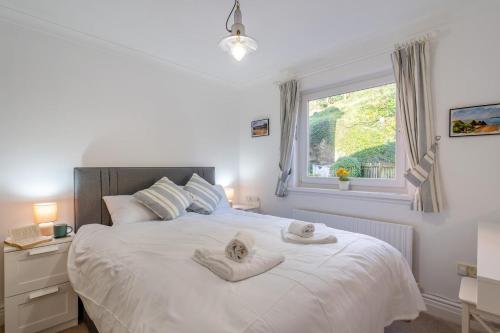 a bedroom with a large white bed with towels on it at 2 Bed in Langland oc-f30206 in Newton