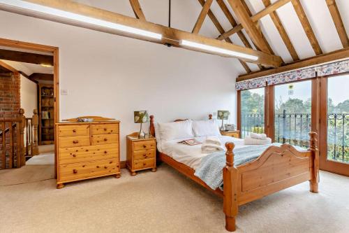 a bedroom with a wooden bed and a window at 4 Bed in Litcham oc-h30106 in Litcham