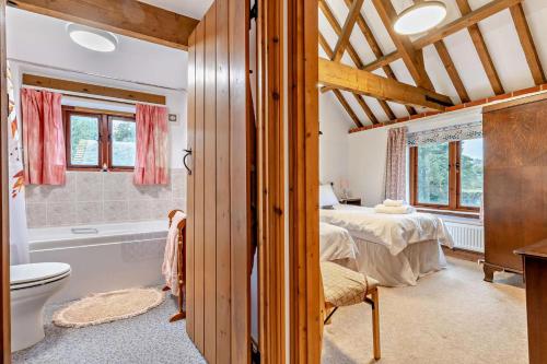 a bedroom with a bed and a tub in a room at 4 Bed in Litcham oc-h30106 in Litcham