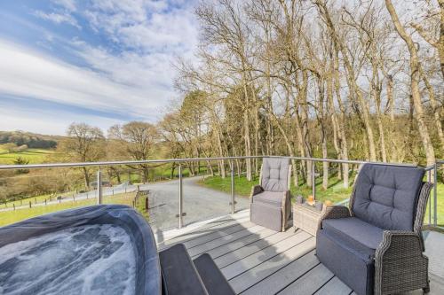 a deck with two chairs and a hot tub at 1 Bed in Berriew oc-a31113 in Berriew