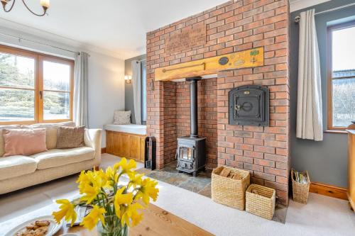 a living room with a brick fireplace with a wood stove at 5 Bed in Ystrad Meurig oc-r31133 in Ystrad Meurig