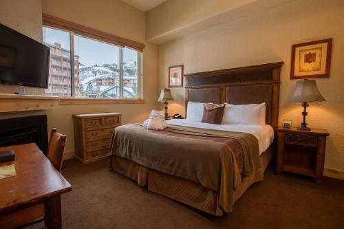 a hotel room with a bed and a desk and a television at Silverado Lodge, Park City - Canyons Village by Vail Resorts in Park City