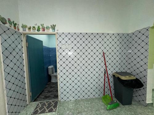 a bathroom with a toilet and a trash can at Olive Cottage in Marang