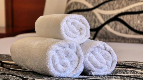 a stack of towels sitting on a bed at Across Country Motor Inn in Dubbo
