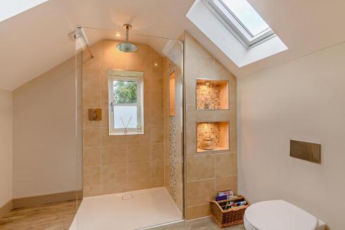 a bathroom with a shower with a toilet and a window at 3 Bed in Syderstone oc-a27669 in Syderstone