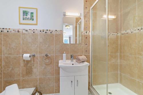 a bathroom with a shower and a toilet and a sink at 5 Bed in Pentney oc-w27337 in Pentney
