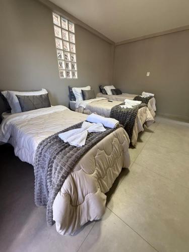 a row of three beds in a room at Serra Premium Residence in Petrópolis