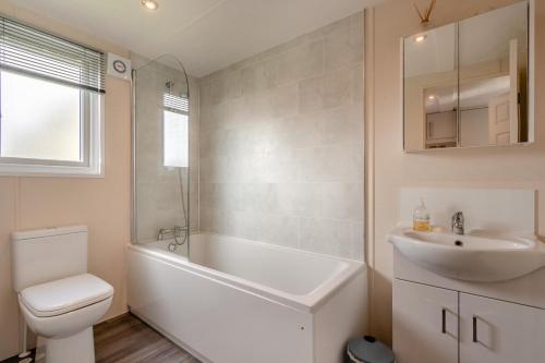 a bathroom with a white tub and a sink and a toilet at 2 Bed in Sewerby oc-s31941 in Sewerby