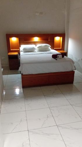 a bedroom with a large bed with two lights on it at Casa Excalibur in Máncora