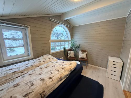 a bedroom with a bed and a window at Sørlandets paradis in Svenevik