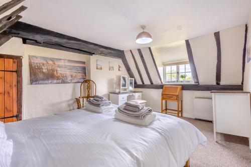a bedroom with a white bed with towels on it at 3 Bed in Stowupland oc-p32216 in Stowmarket