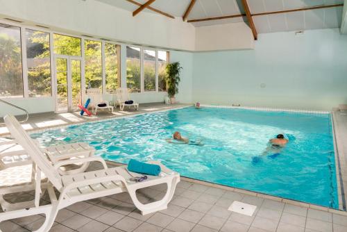 a swimming pool with two people in the water at Espace Leonard De Vinci in Lisses