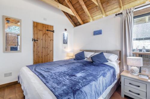 a bedroom with a blue bed and a window at 1 Bed in Swanage oc-l30493 in Langton Matravers