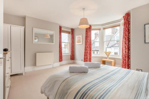 a bedroom with a large bed with red curtains at 4 Bed in Swanage oc-a29454 in Swanage