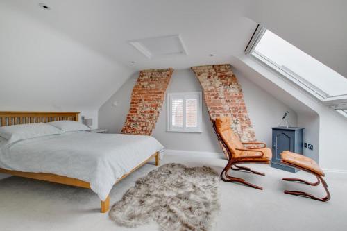 a bedroom with a bed and a chair and a window at 3 Bed in Southwold oc-tlw2 in Southwold