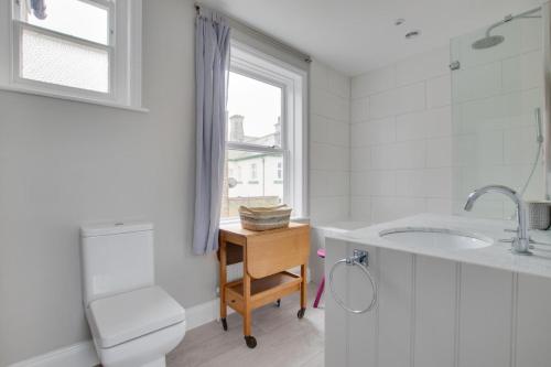 a bathroom with a sink and a toilet and a window at 3 Bed in Southwold oc-tlw2 in Southwold