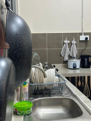 a dish drying rack next to a kitchen sink at RNA Homestay Bayan in Tawau
