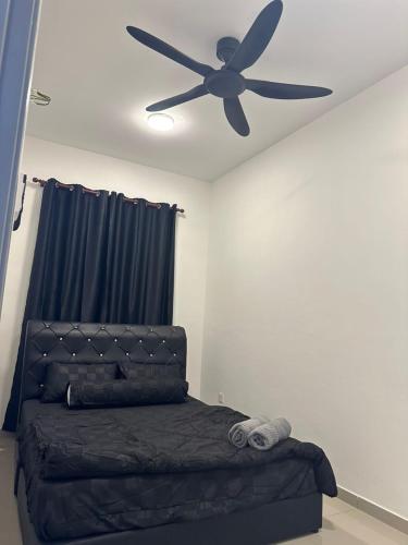 a bedroom with a bed with a ceiling fan at RNA Homestay Bayan in Tawau