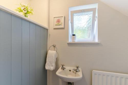 a white bathroom with a sink and a window at 3 Bed in Ashbourne oc-e27970 in Ashbourne