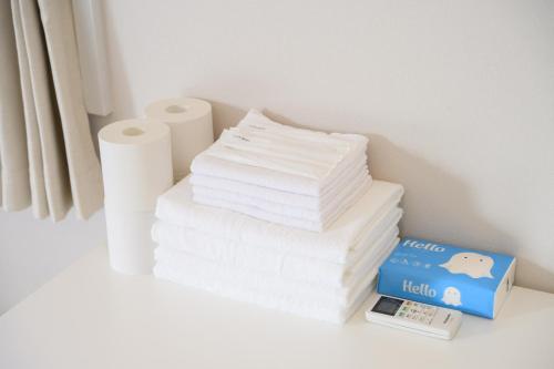 a stack of toilet paper and a pile of towels at Ogi-Ohashi Apartment in Tokyo