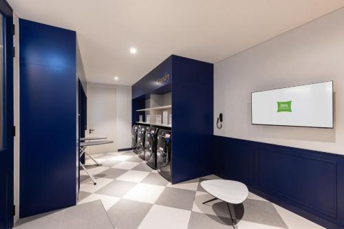 a laundry room with blue walls and a washer and dryer at Ibis Styles Ambassador Seoul Gangnam in Seoul