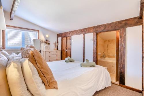 a bedroom with a large bed and a tub at 2 Bed in Sheringham oc-2310 in Sheringham