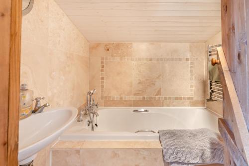 a bathroom with a tub and a sink at 2 Bed in Sheringham oc-2310 in Sheringham