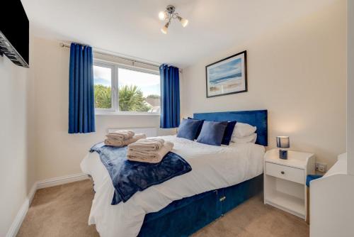 a bedroom with a blue bed and a window at 3 Bed in Higher Crackington oc-avond in Crackington Haven