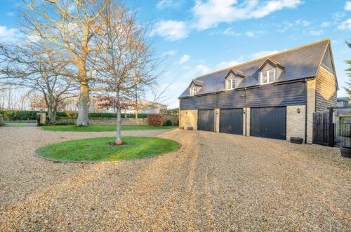 a barn style house with a tree in the driveway at 1 Bed in Woodstock oc-u30547 in Kidlington
