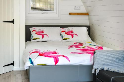 a bed with pink feathers on it in a bedroom at 1 Bed in Abersoch oc-thepod in Abersoch