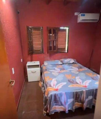 a bedroom with a bed and a red wall at Casona de Montaña in Los Hornillos