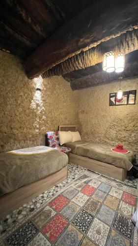 a bedroom with two beds and a rug at Siwa Bait Ward Home in Siwa