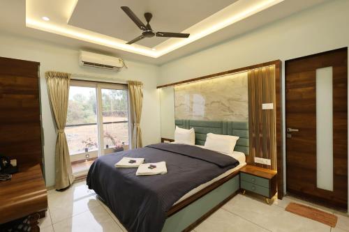 a bedroom with a bed with a ceiling fan and a window at Navishka'S Villa in Panchgani