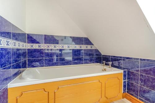 a bathroom with a tub with blue tiles at 2 Bed in Devils Bridge oc-d29575 in Devils Bridge