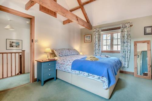 a bedroom with a blue bed and a window at 2 Bed in Corfe Castle oc-a30970 in Corfe Castle