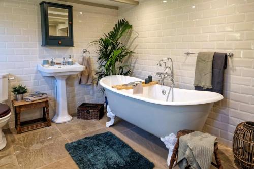 a bathroom with a white tub and a sink at 4 Bed in Little Hayfield oc-c31097 in Hayfield