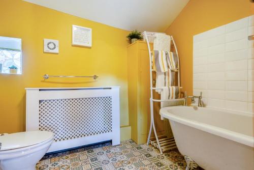 a bathroom with a tub and a toilet and a sink at 1 Bed in Starkholmes oc-q30994 in Matlock Bank