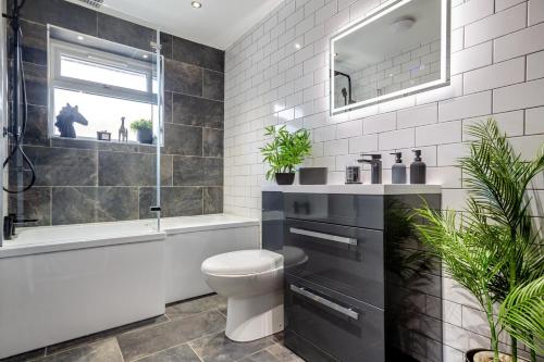 a bathroom with a toilet and a tub and a sink at 3 Bed in Rhyl oc-p30593 in Rhyl