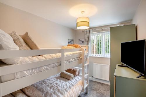 a bedroom with a bunk bed and a flat screen tv at 3 Bed in Rhyl oc-p30593 in Rhyl